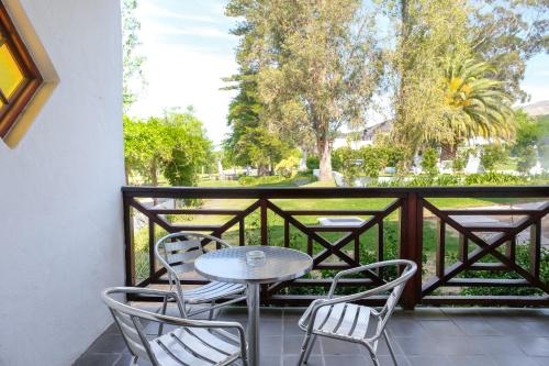 a patio with a table and chairs on a balcony at Houw Hoek Hotel in Botrivier