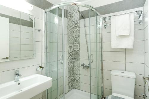 a bathroom with a shower and a toilet and a sink at Castell Hotel in Kissamos