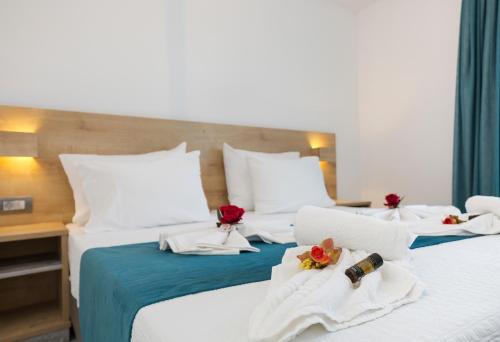 two beds in a hotel room with flowers on them at Castell Hotel in Kissamos