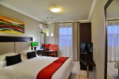 a hotel room with a bed and a television at BON Hotel Empangeni in Empangeni