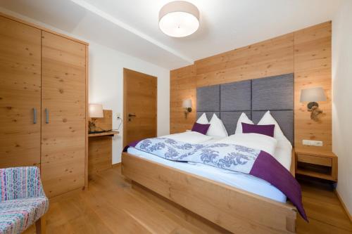 a bedroom with a large bed and wooden walls at Stockhambauer in Kleinarl