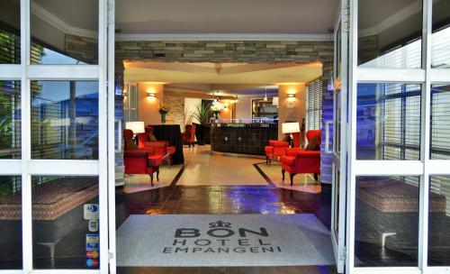 a door to a hotel entrance with red chairs at BON Hotel Empangeni in Empangeni