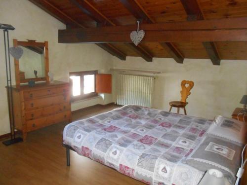 a bedroom with a bed and a dresser in a room at mansarda La Ruine in Morgex
