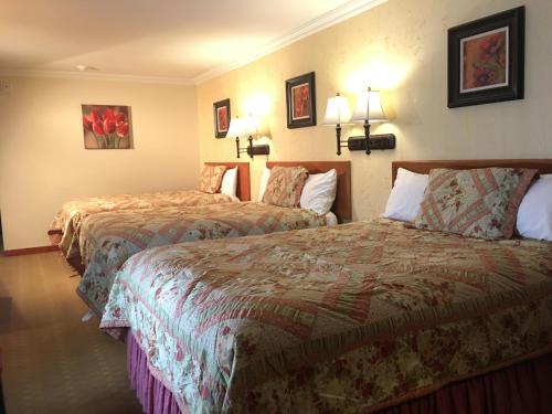 a hotel room with two beds and two lamps at Acorn Motor Inn in Oak Harbor