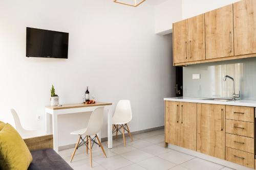 una cocina con armarios de madera, mesa y sillas en Castell Hotel en Kíssamos