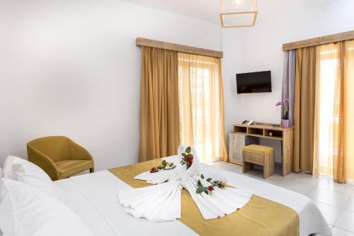 a hotel room with a bed with flowers on it at Castell Hotel in Kissamos