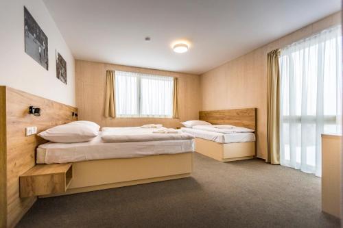 um quarto com 2 camas e uma janela em Hotel Monínec - Depandance Nová Javorka em Moninec