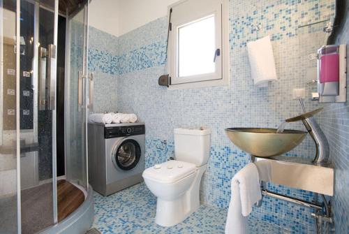 a bathroom with a toilet and a sink and a washing machine at Dream View Villas in Sivota