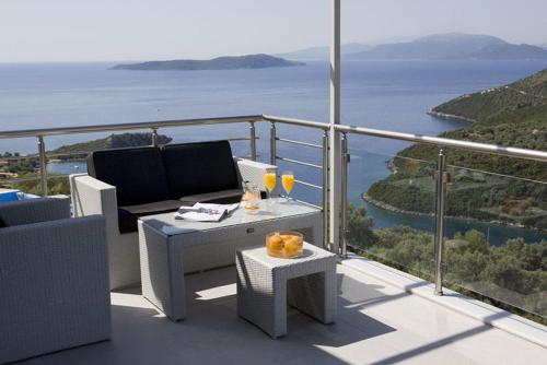 a balcony with a table and two glasses of wine at Dream View Villas in Sivota