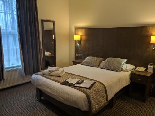 a hotel room with a large bed and a mirror at Best Western Ipswich Hotel in Ipswich