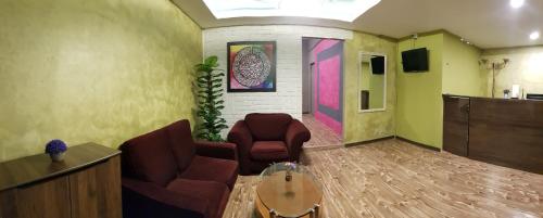 a living room with two chairs and a table at Tc theme park Guest house in Kuantan