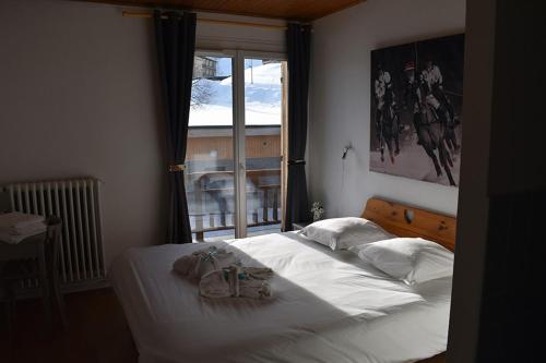 une chambre avec un lit avec deux sacs dessus dans l'établissement La Principauté de Comborciere, à La Toussuire