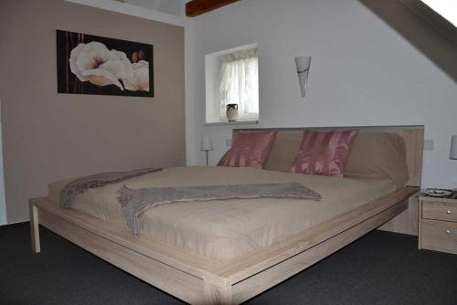 una camera da letto con un grande letto con cuscini rosa di Ferienwohnung am Bannwald 1 a Friburgo in Brisgovia