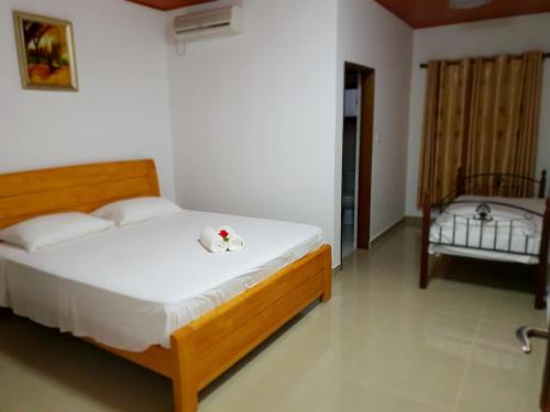 a bedroom with a large bed with white sheets at Tourterelle Holiday Home in Grand Anse