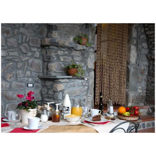 a table with food on it with a stone wall at Agriturismo Montagna Verde Apella in Licciana Nardi