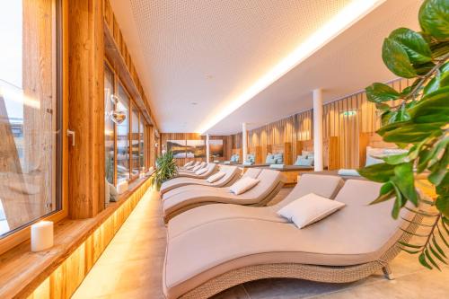eine Reihe weißer Stühle in einem Zimmer mit Fenstern in der Unterkunft Ferienanlage Central in Flachau