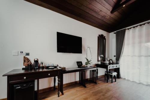 a room with a desk and a tv on the wall at Phor Liang Meun Terracotta Arts in Chiang Mai