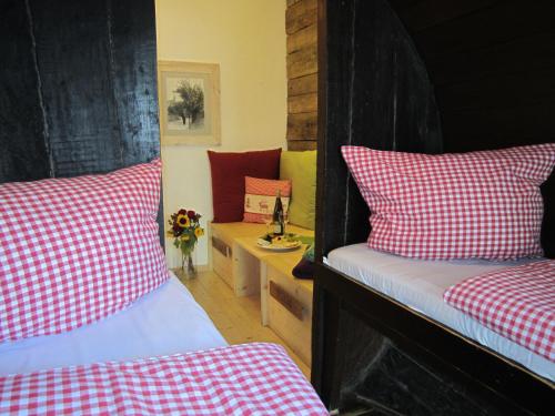 a bedroom with two beds with red and white checked sheets at Hotel Lindenwirt in Rüdesheim am Rhein
