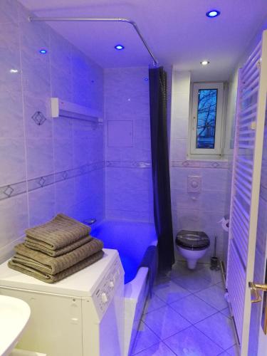 a purple bathroom with a toilet and a shower at Apartment mea in Berlin