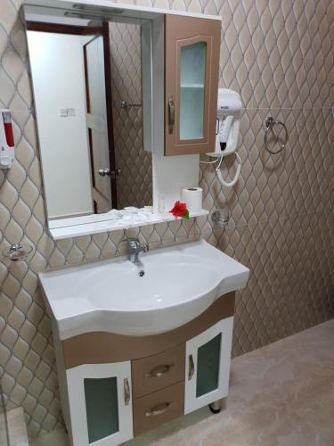 a bathroom with a white sink and a mirror at Tourterelle Holiday Home in Grand Anse