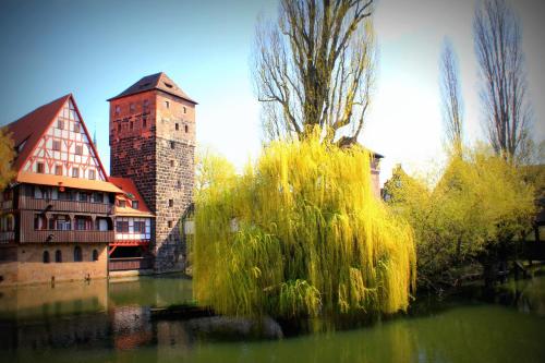 a view of a river with a building and a tower at Burghotel Nürnberg in Nürnberg
