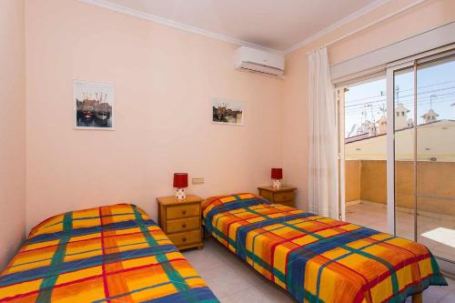 Duas camas num quarto com uma janela em CH Ronda Doña Pepa em Rojales