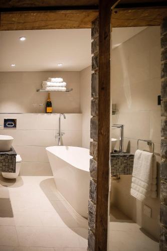 a bathroom with a tub and a toilet and a sink at Gileston Manor-Self catering in Saint Athans