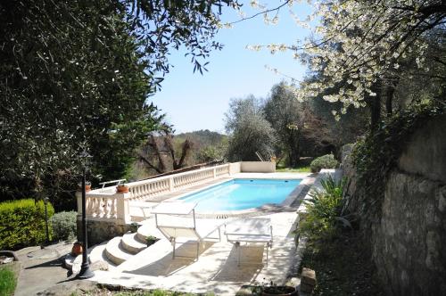 una piscina con 2 sillas junto a una pared en Maison Le Retour, en Le Rouret