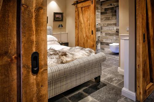 a bedroom with a bed and a couch in a room at Gileston Manor-Self catering in Saint Athans