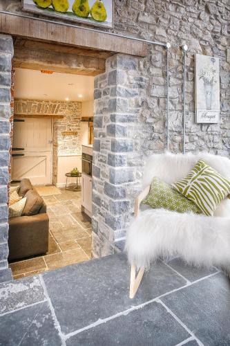 a living room with a couch and a stone wall at Gileston Manor-Self catering in Saint Athans