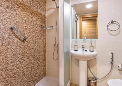 y baño con lavabo, ducha y aseo. en Stellamar - Paseo Maritimo en Fuengirola