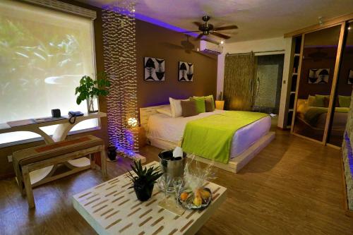 a bedroom with a bed and a table in a room at Le Domaine de L'Orangeraie Resort and Spa in La Digue
