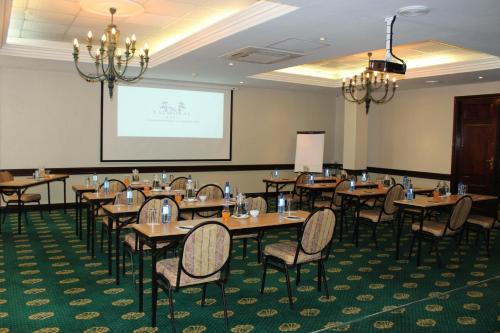 a conference room with tables and chairs and a screen at The Balmoral - Halaal in Durban