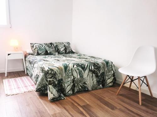 バレンシアにあるGoya aticoのベッドルーム1室(ベッド1台、白い椅子付)