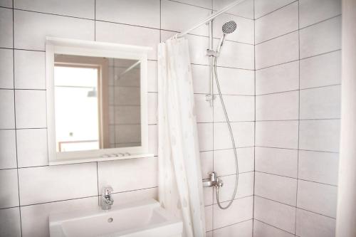 a white bathroom with a sink and a mirror at Pihtoviy Bor Hotel in Dakhovskaya