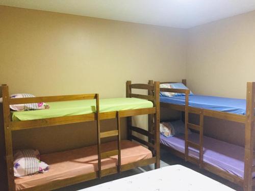 a room with three bunk beds in a room at Duplex Praia dourada in Maragogi