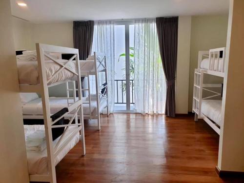 a room with four bunk beds and a balcony at Summer Stay Sattahip in Sattahip