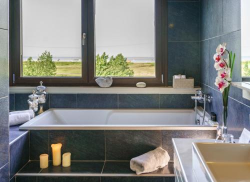 a bathroom with a bath tub and a sink at Cosmopolitan Hotel in Paralia Katerinis