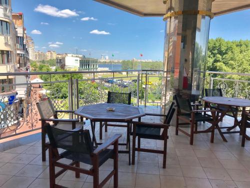 a patio with tables and chairs on a balcony at Sonata Hotel in Kyiv