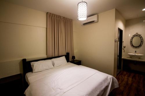 a bedroom with a white bed and a sink at 8 Boutique By The Sea in George Town