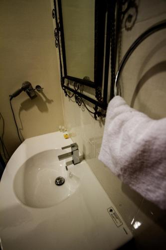 a white sink in a bathroom with a mirror at 8 Boutique By The Sea in George Town