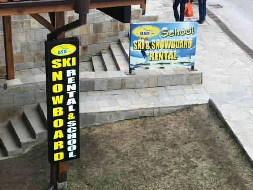 a sign for a ski shop on the side of the street at Gondola Flat Number 5 in Bansko