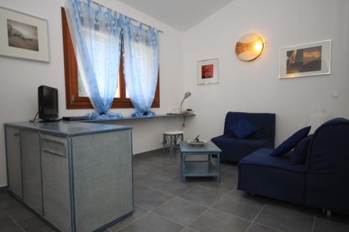 a living room with a blue couch and a tv at Poisson Rouge in Bonifacio