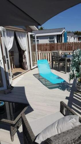 a patio with a blue chair and a table at Southsea, Beach and Beauty Lodges in Portsmouth