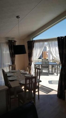 a dining room with a table and a large window at Southsea, Beach and Beauty Lodges in Portsmouth