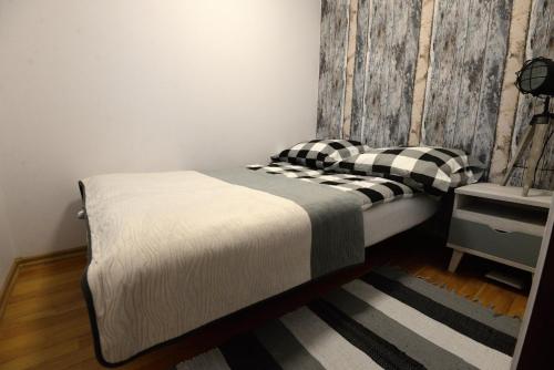 een slaapkamer met een bed en een houten muur bij Apartament Columbus in Ustrzyki Dolne