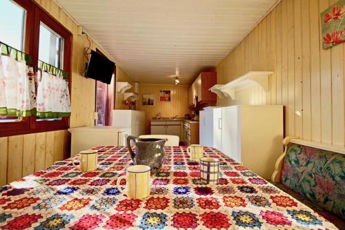a kitchen with a table with a quilt on it at Villa Kunterbunt in Meßkirch