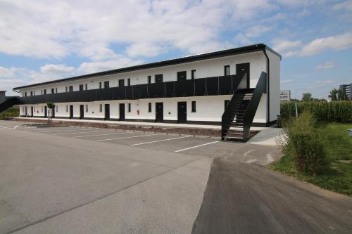 a large white building with a staircase in a parking lot at AI Hotel by WMM Hotels in Aichstetten