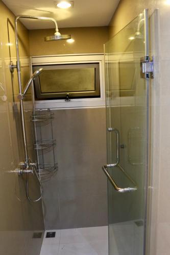 a bathroom with a shower with a glass door at The 21 MuangthongThani in Pak Kret