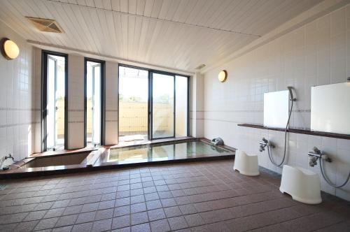 a bathroom with a bath tub and two toilets at Kashikojima Hotel Bay Garden in Shima